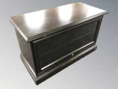 A modern ebonised and glazed entertainment low cabinet, width 98 cm.