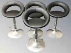 A set of four contemporary chrome and stitched black leather rise and fall bar stools.