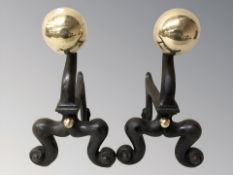 A pair of cast iron and brass fire dogs, height 30 cm.