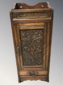 A late Victorian carved oak smoker's cabinet, height 52 cm.