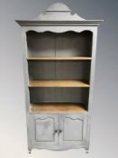 A French style open bookcase, fitted with cupboards beneath,