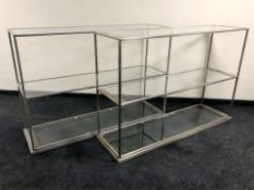 A pair of painted metal and glass three tier shelves, each 148 cm L x 44 cm D x 102 cm H.