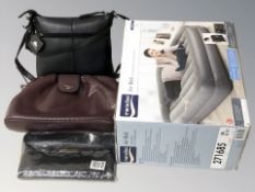 An air bed in box and a group of lady's hand bags.