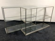 A pair of painted metal and glass three tier shelves, each 148 cm L x 44 cm D x 102 cm H.