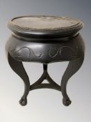 An ebonised circular occasional table on claw and ball feet,