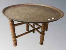 An eastern brass topped circular occasional table, diameter 63 cm.