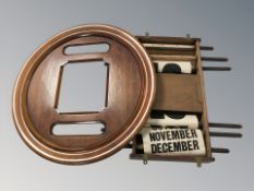 An Edwardian oak scrolling wall calendar,