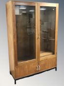 A 20th century teak glazed double door book case with adjustable shelves,