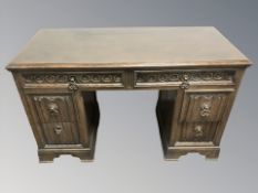 An oak linen fold twin pedestal desk,
