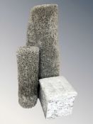 A contemporary upholstered storage stool and two shaggy piled rugs.