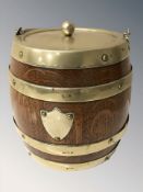 An oak and silver plate-mounted biscuit barrel with swing handle, height 14 cm.