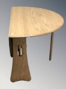 An Ercol light elm gate leg dining table, 120 cm L x 106 cm W x 72 cm H,