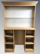 An oak veneered two section display unit, overall 138 cm W x 46 cm D x 221 cm H.