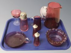 A group of cranberry glass items.