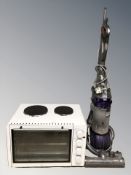 A Dyson DC25 upright vacuum and a bench top oven.