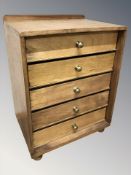 A 20th century teak and ply wood five drawer chest,