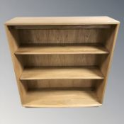 An Ercol light elm three tier open bookcase, 91 cm W x 33 cm D x 100 cm H.