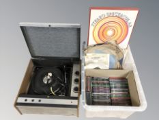 A vintage record player and a box containing assorted LP records, 78s and CDs.