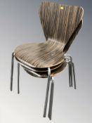 A set of four laminated wood and chrome dining chairs.