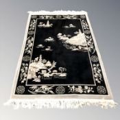 A Chinese rug on black ground, 222 cm x 140 cm.