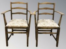 A pair of reproduction oak ladder back armchairs.