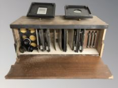 A wooden case containing camera plates and lenses.