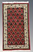 A woolen rug of Persian design, 143 cm x 68 cm.