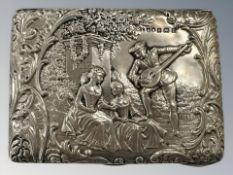 An Edwardian silver repoussé cigarette case/purse, the obverse depicting figures in a garden,