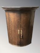 A George III oak hanging corner cabinet,