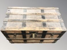 An early 20th century oak and leather bound trunk,