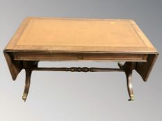 A reproduction mahogany and tooled leather inset drop leaf coffee table,