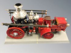 A scale model steam powered engine on plinth,
