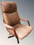 A Scandinavian stitched tan leather upholstered swivel lounge armchair.
