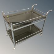 A chrome smoked glass trolley, length 87 cm.