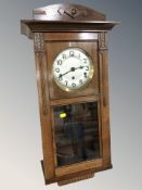 An early 20th century walnut eight day wall clock with silvered dial, pendulum and key,