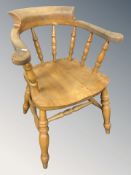 A pine spindle back elbow chair, width 61 cm.