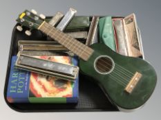 A group of harmonicas / mouth organs, a Blue Moon ukulele and a Harry Potter volume.