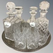 An EPNS circular salver, four various decanters and a set of six crystal tumblers.