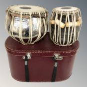 Two Indian drums, tallest 27 cm, together with a storage box.