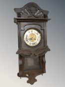 An early 20th century continental oak eight day wall clock, with pendulum, height 87 cm.