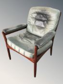 A green leather upholstered Scandinavian armchair.