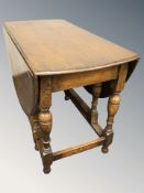 An oak drop leaf gate leg dining table and a harlequin set of four elm spindle back chairs.