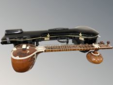 A sitar, length 124 cm, in hard carry case.