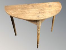 A 19th century pine demi-lune table,