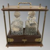 A modern mahogany and brass Tantalus with two decanters and labels, with key, height 36 cm.