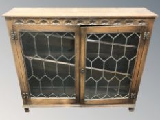 An oak and leaded glass double door display cabinet, 122 cm x 30 cm x 107 cm.