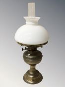 A brass oil lamp with opaque glass shade, height 49 cm.