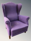 A late 20th century wingback armchair in purple fabric.