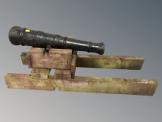 An ornamental cast iron cannon on wooden carriage, length 91 cm.