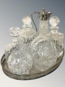An EPNS oval drinks tray containing three decanters, vase, basket and an EPNS mounted claret jug.